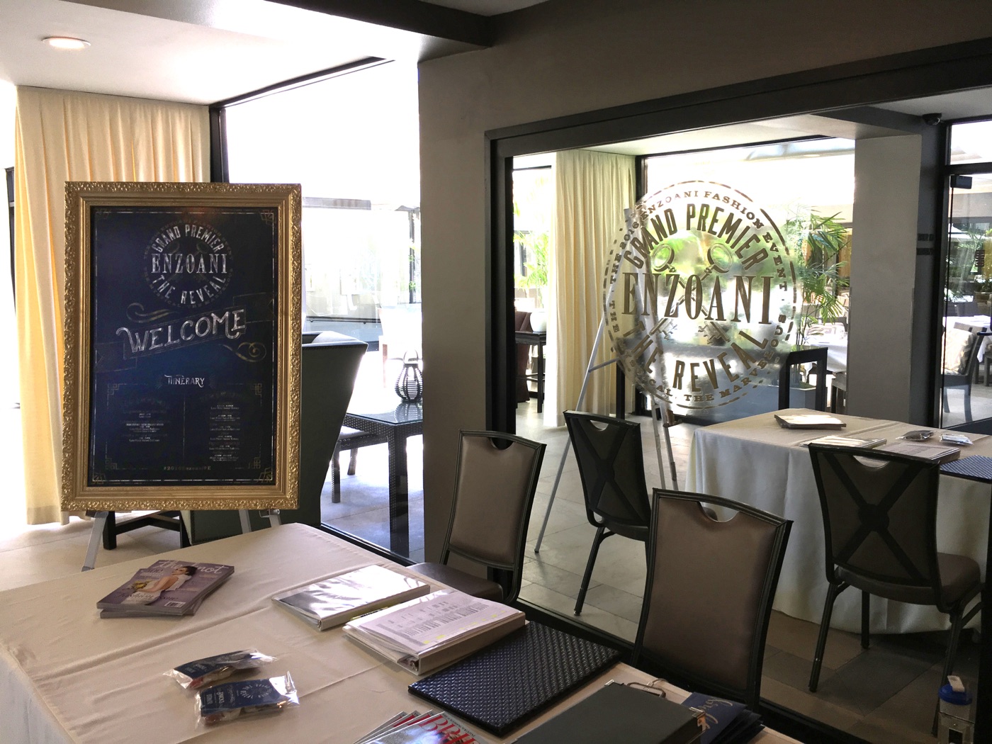 2016 Enzoani Grand Premier check-in lobby with a gold-framed welcome chalkboard and the event mark on the window